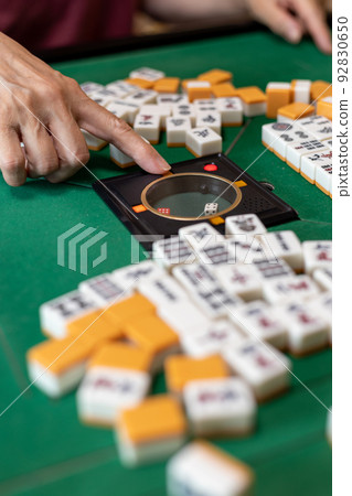 高級女性在電動麻將桌上推骰子按鈕的手 高級女性在電動麻將桌上推骰子按鈕的手 92830650