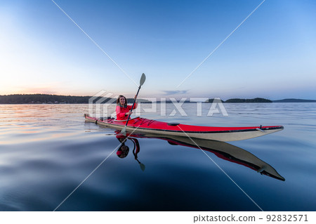 Adventurous Woman on Sea Kayak paddling in the Pacific Ocean Adventurous Woman on Sea Kayak paddling in the Pacific Ocean 92832571