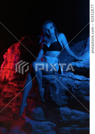 rose toy useage Fashion woman model in fashionable dress in colorful neon lights at studio.  Portrait of stylish sexy girl in trendy clothes over bright pink and purple  ultraviolet light at night club. Style photo –