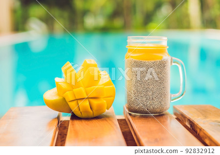 Chia seed pudding with almond milk and fresh mango topping on the background of the pool Chia seed pudding with almond milk and fresh mango topping on the background of the pool 92832912