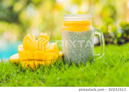 Chia seed pudding with almond milk and fresh mango topping on the background of the pool Chia seed pudding with almond milk and fresh mango topping on the background of the pool 92832913