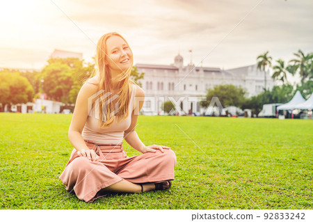 Woman on background of City Hall in George Town - Penang, Malaysia. British built historical building completed 1903 became the City Hall of George Town 1957 92833242