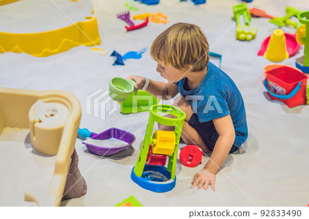 Boy playing with sand in preschool. The development of fine motor concept. Creativity Game concept Boy playing with sand in preschool. The development of fine motor concept. Creativity Game concept 92833490