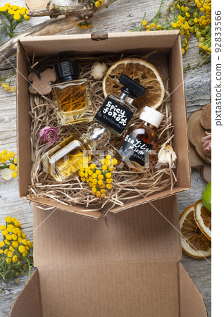 author collection of perfumes around yellow flowers and ingridients served in box .top view. perfumery and life style concept author collection of perfumes around yellow flowers and ingridients served in box .top view. perfumery and life style concept 92833566