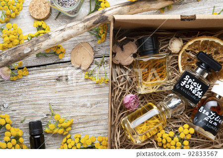 author collection of perfumes around yellow flowers and ingridients served in box .top view. perfumery and life style concept author collection of perfumes around yellow flowers and ingridients served in box .top view. perfumery and life style concept 92833567