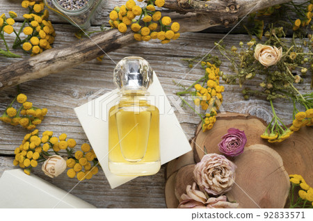 perfume bottles around yellow flowers and ingridients at wooden old style background . flat lay. perfumery concept perfume bottles around yellow flowers and ingridients at wooden old style background . flat lay. perfumery concept 92833571