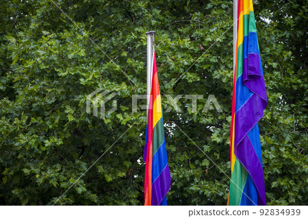 Close-Up rainbow gay pride flag outside on a street. Symbol of the Lesbian Bisexual Transgender LGBT community waving in wind against cloudy sky. Social movement for freedom and equliaty. Copy Space Close-Up rainbow gay pride flag outside on a street. Symbol of the Lesbian Bisexual Transgender LGBT community waving in wind against cloudy sky. Social movement for freedom and equliaty. Copy Space 92834939