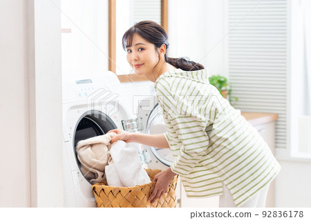 young woman doing laundry 92836178