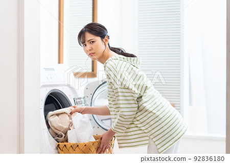 young woman doing laundry 92836180