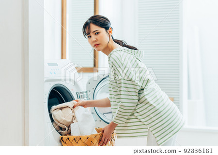 young woman doing laundry young woman doing laundry 92836181