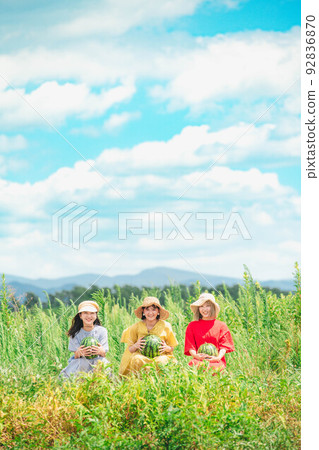 Women sitting with watermelons under the blue sky 92836870