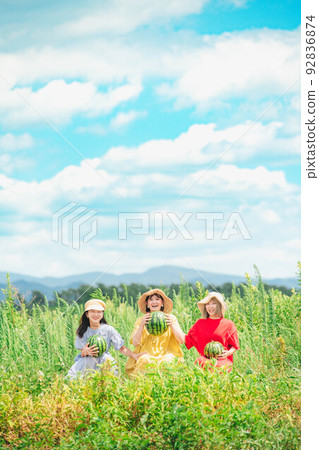 Women sitting with watermelons under the blue sky 92836874