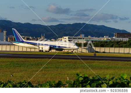 Itami Airport at dusk, a jet airliner on the taxiway Itami Airport at dusk, a jet airliner on the taxiway 92836886