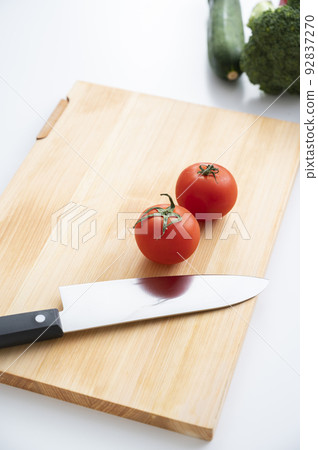 Cypress cutting board, kitchen knife and vegetables Cypress cutting board, kitchen knife and vegetables 92837270