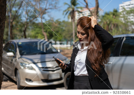 Woman drivers call insurance after a car accident before taking pictures and sending insurance. Online car accident insurance claim idea after submitting photos and evidence to an insurance company. Woman drivers call insurance after a car accident before taking pictures and sending insurance. Online car accident insurance claim idea after submitting photos and evidence to an insurance company. 92838661