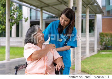 Asian careful caregiver or nurse taking care of the patient in a wheelchair. Concept of happy retirement with care from a caregiver and Savings and senior health insurance, a Happy family Asian careful caregiver or nurse taking care of the patient in a wheelchair. Concept of happy retirement with care from a caregiver and Savings and senior health insurance, a Happy family 92838991