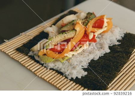 Process of preparing vegan sushi roll futomaki with pepper cucumber and avocado salad 92839216