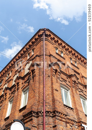 An old large brick building with a white sign for the name of a cafe 92839469