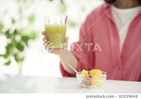 中間女人的手吃綠色冰沙和水果 92839648