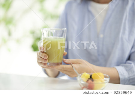 中間女人的手吃綠色冰沙和水果 92839649