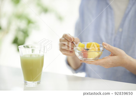 中間女人的手吃綠色冰沙和水果 92839650