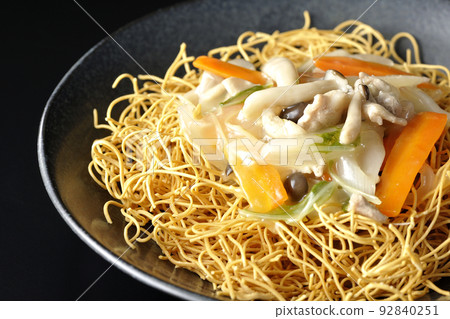 Sara-udon with bean paste containing shimeji mushrooms, carrots, onions, etc. photographed against a black background 92840251