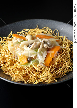 Sara-udon with bean paste containing shimeji mushrooms, carrots, onions, etc. photographed against a black background 92840257