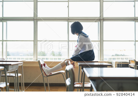 high school girl sitting on desk 92840414