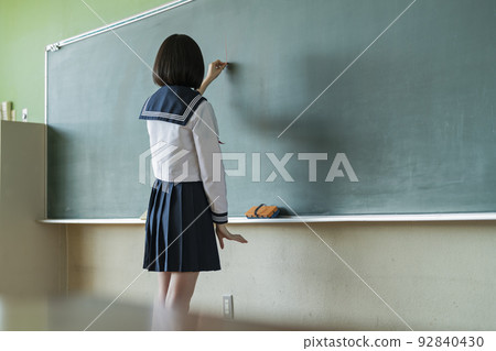 School girls who write letters on the blackboard 92840430