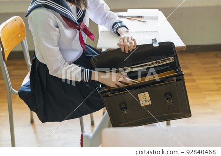 Classroom High school girl looking for something left behind Classroom High school girl looking for something left behind 92840468