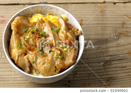 A bird's-eye view of a teriyaki chicken bowl with a large piece of chicken on top of an egg A bird's-eye view of a teriyaki chicken bowl with a large piece of chicken on top of an egg 92840662