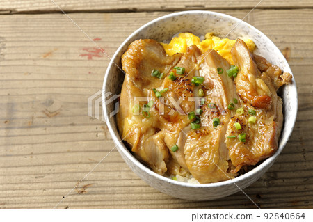 A bird's-eye view of a teriyaki chicken bowl with a large piece of chicken on top of an egg A bird's-eye view of a teriyaki chicken bowl with a large piece of chicken on top of an egg 92840664