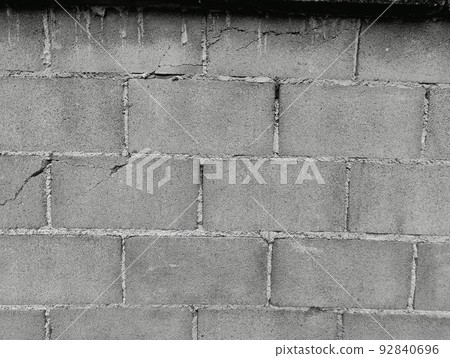Close-up of White cement crack block wall and peeled paint caused by water and sunlight. Peel wall of White house paint with black stain. Black and White of Texture background. Close-up of White cement crack block wall and peeled paint caused by water and sunlight. Peel wall of White house paint with black stain. Black and White of Texture background. 92840696