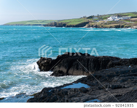 A beautiful sea bay on the south coast of Ireland near Clonakilty on a sunny day. Waves and coastal rocks under a clear blue sky. The beauty of Irish nature. Turquoise sea water, rock formation on sea A beautiful sea bay on the south coast of Ireland near Clonakilty on a sunny day. Waves and coastal rocks under a clear blue sky. The beauty of Irish nature. Turquoise sea water, rock formation on sea 92841935