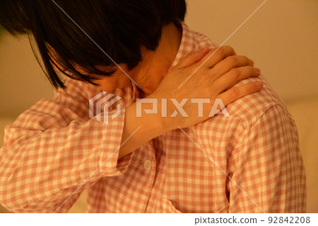 臥室裡一名穿著睡衣肩膀僵硬的中年婦女 92842208