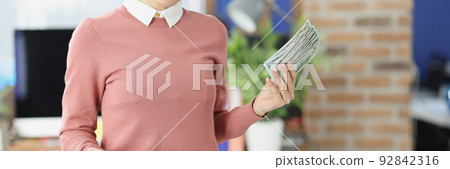 In the office, a happy woman prints dollars on a printer 92842316