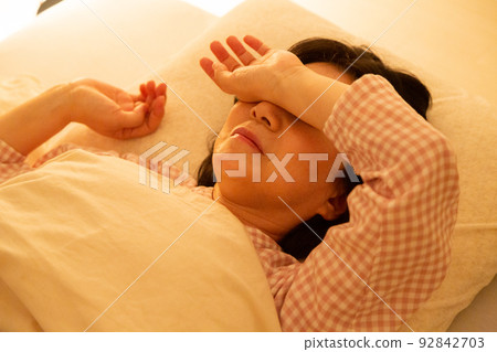 一個穿著睡衣睡在臥室裡的中年婦女 92842703