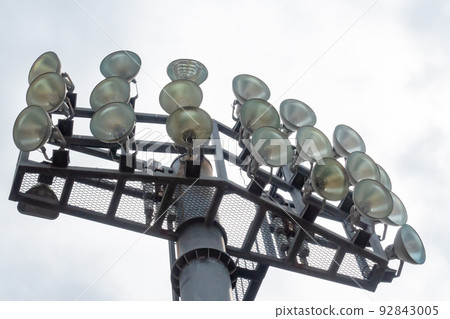 A photo of a large outdoor light on a baseball field. 92843005