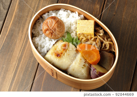 西京燒便當盒的鳥瞰圖,米飯、玉子燒和燉菜上放著大醃李子。 西京燒便當盒的鳥瞰圖,米飯、玉子燒和燉菜上放著大醃李子。 92844669