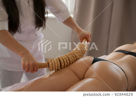 Stimulation lymphatic system with wood therapy treatment. Massage with wooden Stimulation lymphatic system with wood therapy treatment. Massage with wooden 92844829