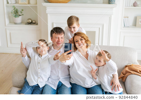 Happy loving family five using smartphone for video calling with family 92844840