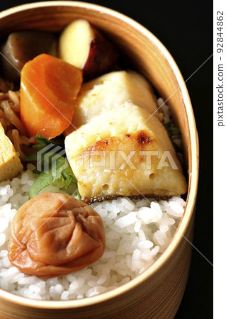 銀鱈魚 saikyo-yaki 便當,在米飯、玉子燒和燉菜上放一個大 umeboshi,在黑色背景下拍照。 銀鱈魚 saikyo-yaki 便當,在米飯、玉子燒和燉菜上放一個大 umeboshi,在黑色背景下拍照。 92844862