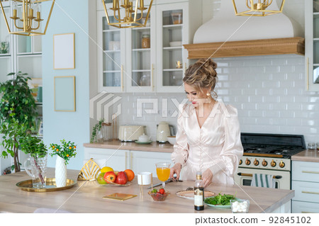 Girl cuts fruit salad with strawberries on cutting board with knife. Concept Girl cuts fruit salad with strawberries on cutting board with knife. Concept 92845102