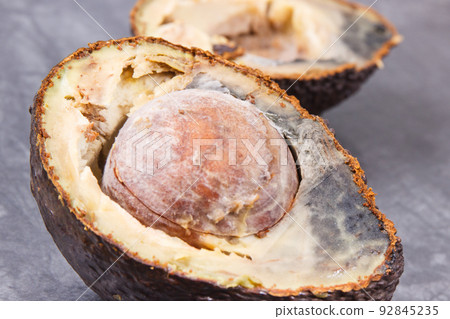 Inedible avocado with mold. Dark background. Unhealthy food Inedible avocado with mold. Dark background. Unhealthy food 92845235