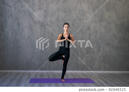 Athletic young woman doing yoga isolated on gray wall background in black 92846525