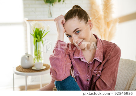 Calm young caucasian woman sitting on a comfortable chair and enjoying 92846986