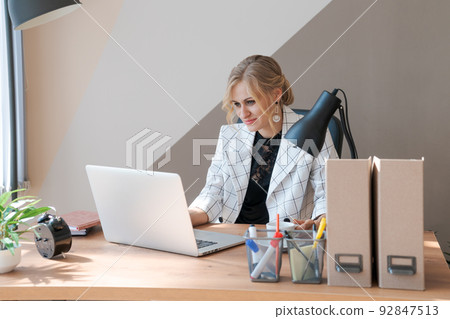 Head Shot Pleasant Happy Young Woman Freelancer working on computer at home. 92847513