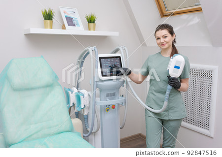 Woman doctor in medicine salon holds vacuum massage apparatus. Anti-cellulite 92847516