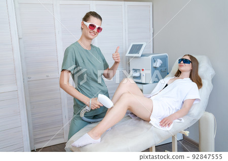 Laser hair removal in beauty salon. Woman has removal procedure, caucasian girl 92847555