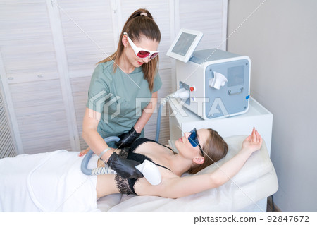 Laser hair removal in beauty salon. Woman has removal procedure, caucasian girl 92847672